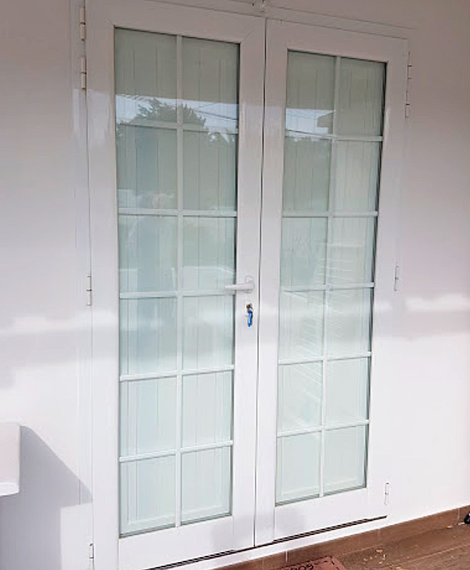 Puerta exterior de aluminio lacado blanco para vivienda en Ibiza